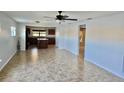 Open living room with tile floors, kitchen view, and ceiling fan at 19261 Isadora St, Venice, FL 34293