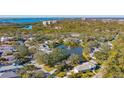 An aerial view showcasing a waterfront community and a homesite with mature trees at 32 Bayhead Ln, Osprey, FL 34229