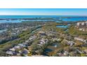 An aerial view showcasing a waterfront community and a homesite with mature trees at 32 Bayhead Ln, Osprey, FL 34229