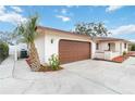 Attached garage with brown door and side yard landscaping at 320 Whitfield Ave, Sarasota, FL 34243