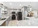 Modern kitchen featuring gray cabinets, granite countertops, and stainless steel appliances at 320 Whitfield Ave, Sarasota, FL 34243