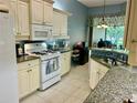 Spacious kitchen featuring white cabinets, granite countertops, and tile backsplash at 3312 92Nd E Ave, Parrish, FL 34219