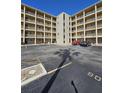 Low angle shot showing parking lot and condo exterior with multiple balconies and unit entrances in the center at 3682 Lake Bayshore Dr # K402, Bradenton, FL 34205