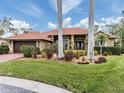 House with red tile roof, palm trees, and well-maintained landscaping at 4539 Longspur Ln, Sarasota, FL 34238