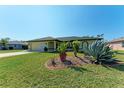 Landscaped front yard with agave plants and a view of the house's facade at 5 Pinehurst Ct, Rotonda West, FL 33947