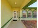 Front entryway with a glass door, arched windows, and a covered porch at 5 Pinehurst Ct, Rotonda West, FL 33947