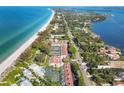 Aerial view showcasing beachfront property, tennis courts, and community at 5055 Gulf Of Mexico Dr # 424, Longboat Key, FL 34228