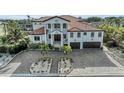 Two-story home with tile roof, double garage, and paved driveway at 550 Yardarm Ln, Longboat Key, FL 34228