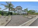 Mediterranean-style home with palm trees and a brick driveway at 550 Yardarm Ln, Longboat Key, FL 34228