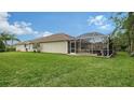 Spacious backyard with a screened lanai and lush green grass at 5890 Guarino Dr, Sarasota, FL 34238