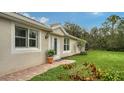 Home's side view, showcasing a white door, plant, and grassy lawn at 5890 Guarino Dr, Sarasota, FL 34238