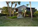 Charming home exterior with a large screened-in porch and balcony surrounded by lush tropical landscaping at 631 43Rd Street W Blvd, Palmetto, FL 34221