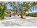 Beautiful two-story home with a three-car garage and white gravel landscaping surrounded by mature trees at 631 43Rd Street W Blvd, Palmetto, FL 34221