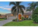 Single-story home with landscaped yard, paver driveway, and two-car garage at 7312 Riviera Cv, Lakewood Ranch, FL 34202