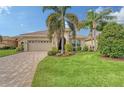 Single-story home with landscaped yard, paver driveway, and two-car garage at 7312 Riviera Cv, Lakewood Ranch, FL 34202