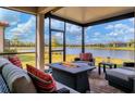 Relaxing screened patio with fire pit overlooking lake at 7432 Summerland Cv, Lakewood Ranch, FL 34202