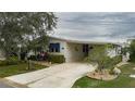 Front view of manufactured home with driveway and landscaping at 8414 Imperial Cir, Palmetto, FL 34221