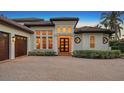 Home exterior featuring a three-car garage and a brick paver driveway at 8994 Wildlife Loop, Sarasota, FL 34238