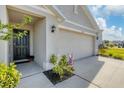 Front entrance with a dark door, two-car garage, and landscaping at 10328 Charlotte Dr, Parrish, FL 34219