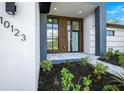 Modern front entrance with wood-paneled door and gray stone walkway at 13377 Alocasia Ln, Port Charlotte, FL 33981