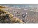 Relaxing beach with lounge chairs and umbrellas at 1465 Gulf Of Mexico Dr # 402, Longboat Key, FL 34228