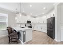 Modern kitchen featuring white cabinets, a large island, and stainless steel appliances at 16135 Paynes Mill Dr, Bradenton, FL 34211