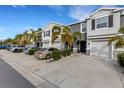 Row of townhomes with gray siding, two-car garages, and landscaping at 2471 Midnight Pearl Dr, Sarasota, FL 34240