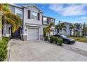 Two-story townhome with gray siding, two-car garage, and driveway at 2471 Midnight Pearl Dr, Sarasota, FL 34240