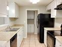 Modern kitchen with white cabinets, black appliances, and tile floors at 320 Cardinal Rd, Venice, FL 34293