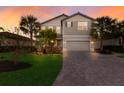 Two-story house with gray siding, brown roof, and a paved driveway at 3324 Big Sky Way, Lakewood Ranch, FL 34211