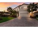 Two-story house with gray siding, brown roof, and a paved driveway at 3324 Big Sky Way, Lakewood Ranch, FL 34211