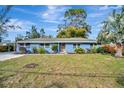 Charming light blue house with a well-maintained lawn and mature trees at 3902 11Th W Ave, Bradenton, FL 34205