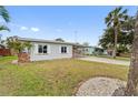 Landscaped yard with a spacious lawn and palm trees at 4026 Indianapolis Ne St, St Petersburg, FL 33703