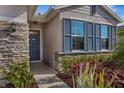 Front entry with stone accents and a dark gray door at 4110 Mossy Limb Ct, Palmetto, FL 34221