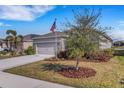 Landscaped yard with mature trees and a welcoming front porch at 4110 Mossy Limb Ct, Palmetto, FL 34221