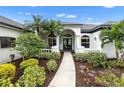 Front entrance with arched entryway, columns, and lush landscaping at 7117 River Club Blvd, Bradenton, FL 34202