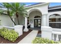 Covered front porch with arched entryway, columns, and seating area at 7117 River Club Blvd, Bradenton, FL 34202