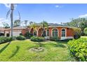 Orange house with arched entryway and lush landscaping at 8628 Woodbriar Dr, Sarasota, FL 34238