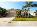 Tan single-story house with a two-car garage, palm trees, and manicured lawn at 8752 Monterey Bay Loop, Bradenton, FL 34212