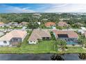 Aerial view showcasing a home's backyard oasis with a pool and canal access at 115 Grand Oak Cir, Venice, FL 34292