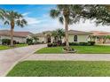 Inviting front view of a home with palm trees and a manicured lawn at 115 Grand Oak Cir, Venice, FL 34292