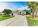 Single-story home with a light-colored facade, landscaping, and a driveway at 120 Grand Oak Cir, Venice, FL 34292