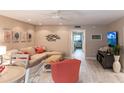 Bright living room with L-shaped sofa, coral chair, and access to other rooms at 145 Avenida Messina # 3, Sarasota, FL 34242