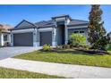 Two-story house with gray exterior, three-car garage, and landscaped yard at 18096 Home Run Dr, Venice, FL 34293