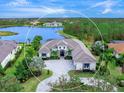 Luxury home with lake views, spacious driveway, and lush landscaping at 19458 Beacon Park Pl, Lakewood Ranch, FL 34202