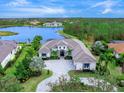 Luxury home with lake views, spacious driveway, and lush landscaping at 19458 Beacon Park Pl, Lakewood Ranch, FL 34202