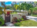 House with red door, wooden gate, and nicely landscaped yard at 3414 Old Oak Dr, Sarasota, FL 34239