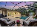 Inviting pool area with patio furniture under a screened enclosure at 3414 Old Oak Dr, Sarasota, FL 34239