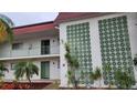 Condo building entryway, featuring a unique wall design and landscaping at 3606 Beneva Rd # 502, Sarasota, FL 34232