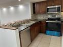 Modern kitchen with dark wood cabinets, stainless steel appliances, and granite counters at 3606 Beneva Rd # 502, Sarasota, FL 34232